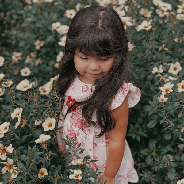 Person meditating peacefully outdoors surrounded by green nature.